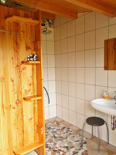 Dusche und Toiletten im Blockbohlenhaus am Natur-Schwimmpool
